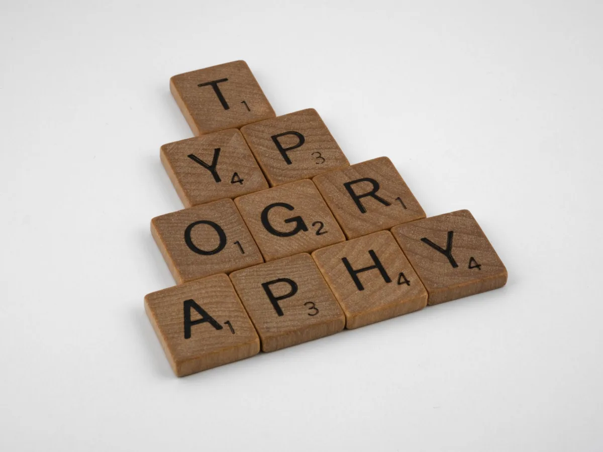 Close-up of wooden Scrabble tiles spelling 'Typography' on a white background. Close-up of wooden Scrabble tiles spelling 'Typography' on a white background.