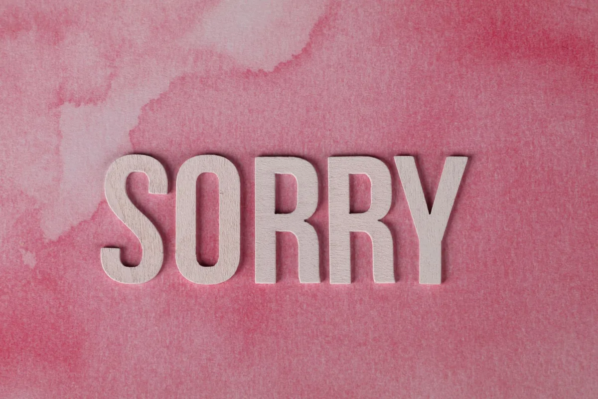 The word 'Sorry' displayed on a pink watercolor textured background, expressing an apology. The word 'Sorry' displayed on a pink watercolor textured background, expressing an apology.