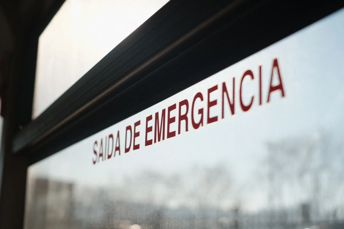 Close-up of exit window with text 'SAIDA DE EMERGENCIA' in Barcelona bus.