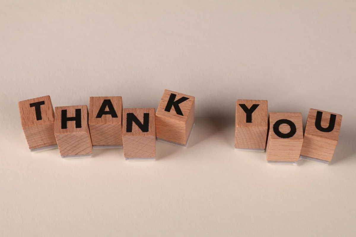 Wooden blocks spell 'THANK YOU' on a soft beige background, expressing gratitude. Wooden blocks spell 'THANK YOU' on a soft beige background, expressing gratitude.