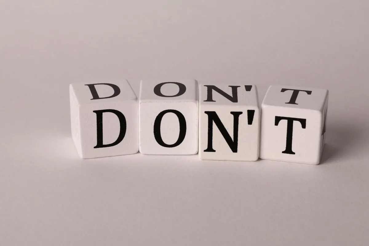Text cubes spelling 'DON'T' on a clean white background, ideal concepts of caution or prohibition.