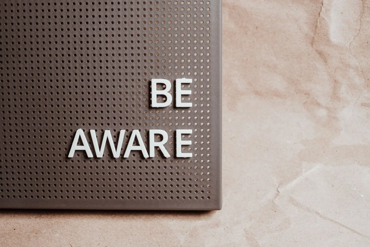 Be Aware wording on brown textured perforated surface, offering copyspace.