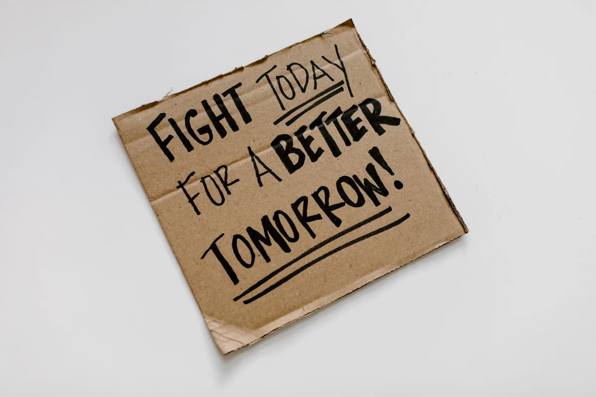 Cardboard sign with 'Fight today for a better tomorrow!' message on a white background. Cardboard sign with 'Fight today for a better tomorrow!' message on a white background.