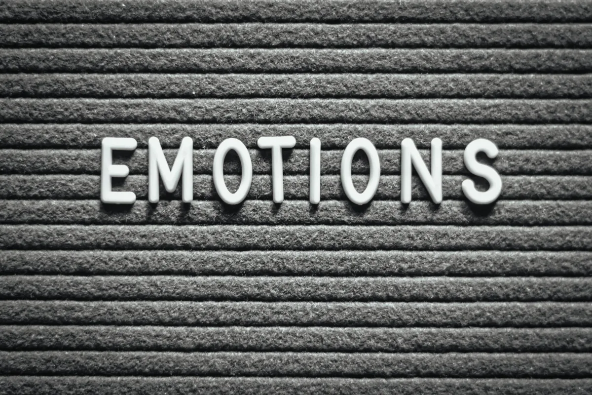 Letter board with the word 'Emotions' on a gray lined background.