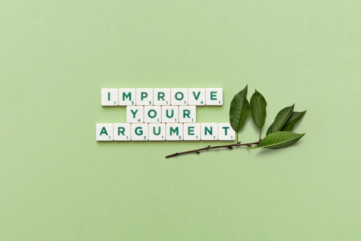 Scrabble tiles spelling 'Improve Your Argument' on a green background with leaves. Scrabble tiles spelling 'Improve Your Argument' on a green background with leaves.