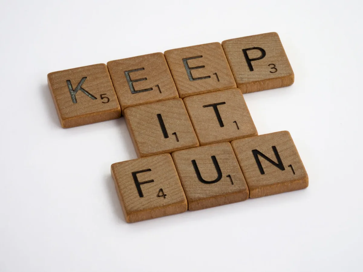 Wooden Scrabble tiles spelling "KEEP IT FUN" on a white surface, creating an engaging and playful Wooden Scrabble tiles spelling "KEEP IT FUN" on a white surface, creating an engaging and playful