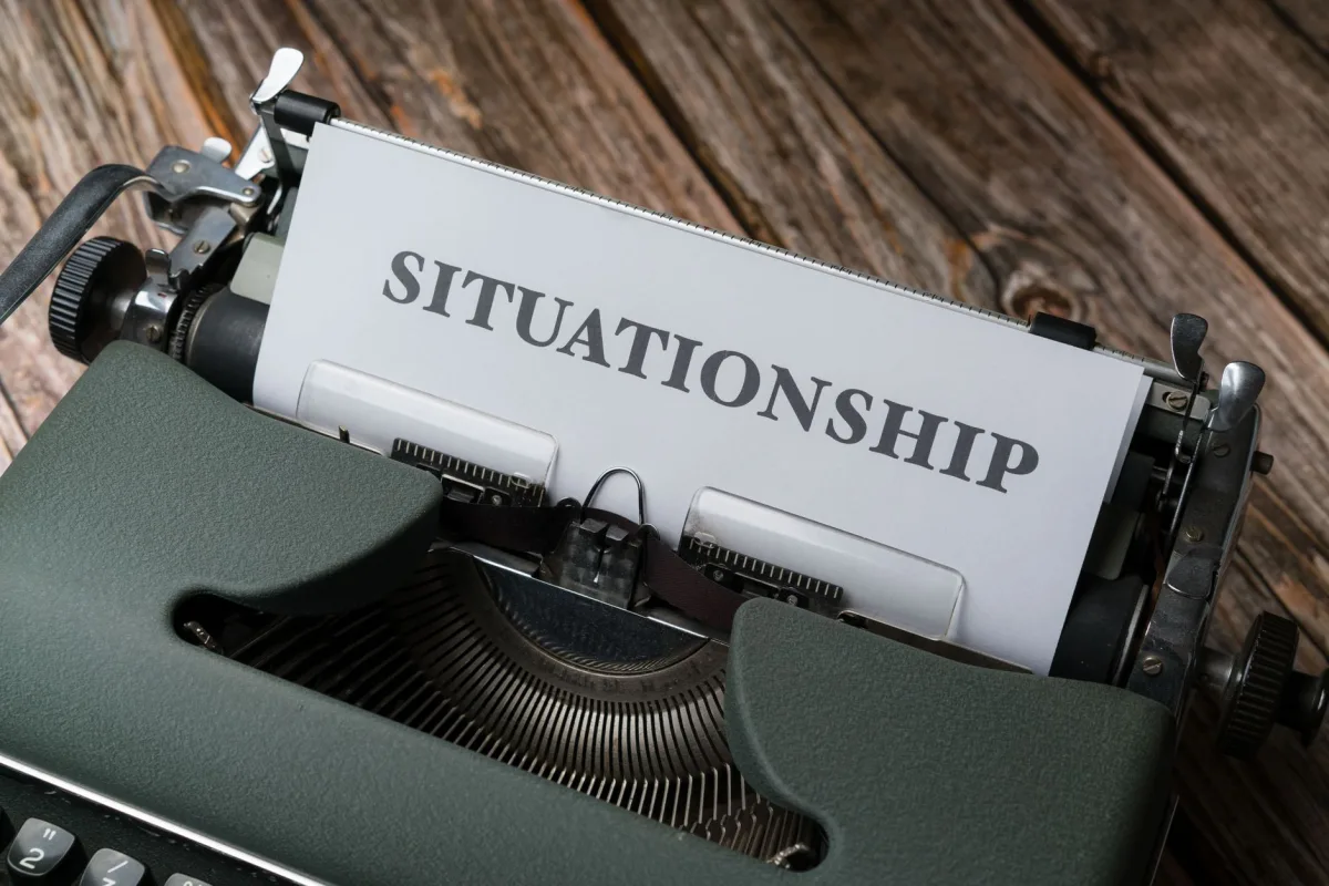 Close-up of a vintage typewriter with "Situationship" typed on paper, symbolizing modern dating concepts. Close-up of a vintage typewriter with "Situationship" typed on paper, symbolizing modern dating concepts.