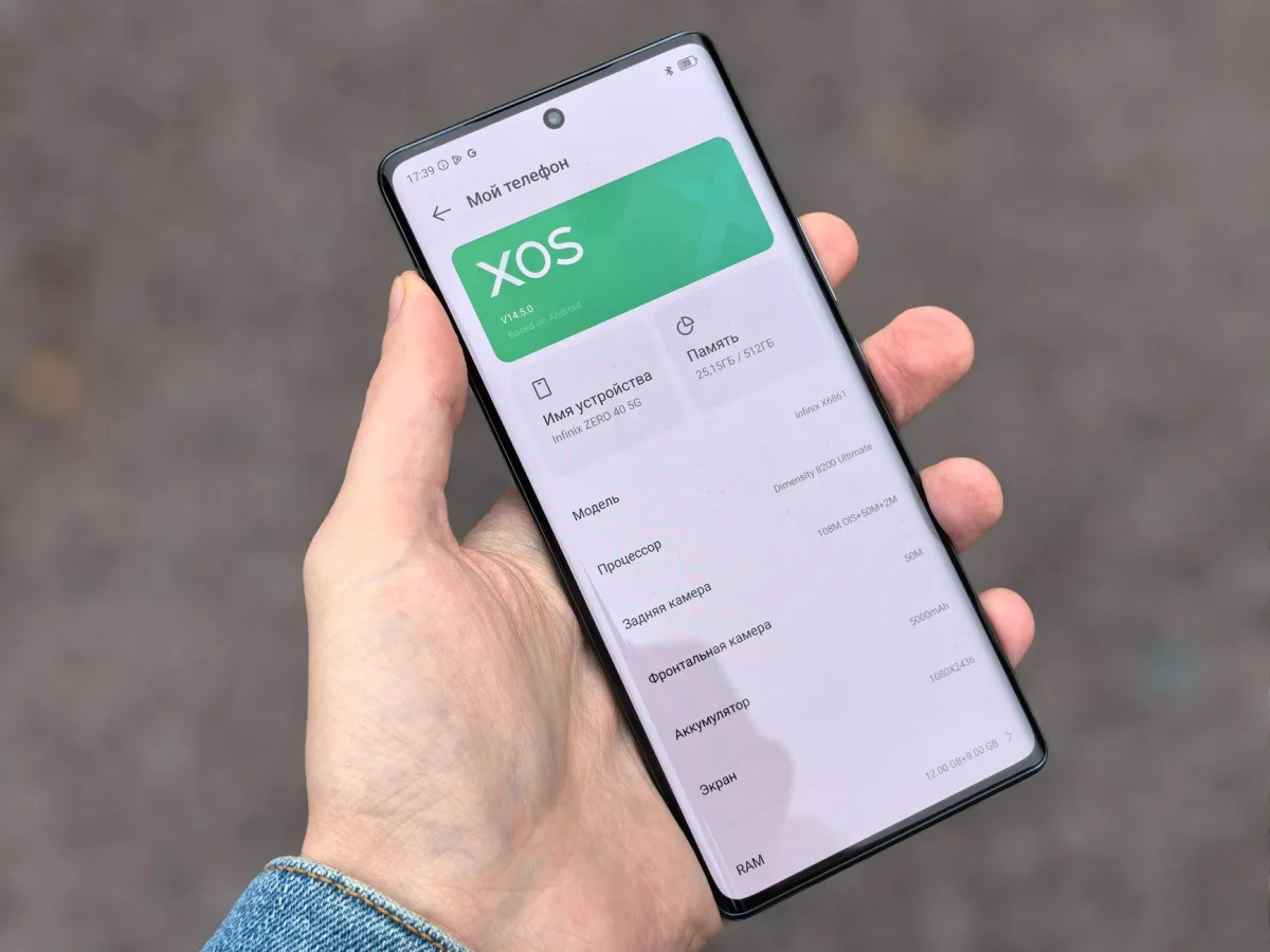 Person holding smartphone showing XOS interface on the screen, captured outdoors. Person holding smartphone showing XOS interface on the screen, captured outdoors.