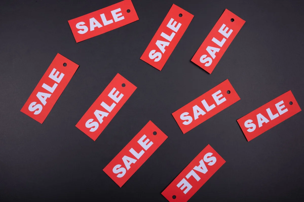 Top view of red sale tags on a black surface, perfect for marketing promotions. Top view of red sale tags on a black surface, perfect for marketing promotions.