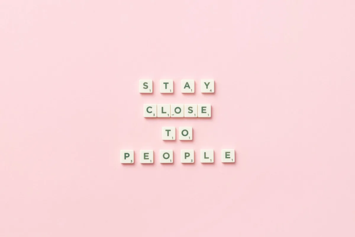 Inspirational quote 'Stay Close To People' on pink background with scrabble tiles. Inspirational quote 'Stay Close To People' on pink background with scrabble tiles.