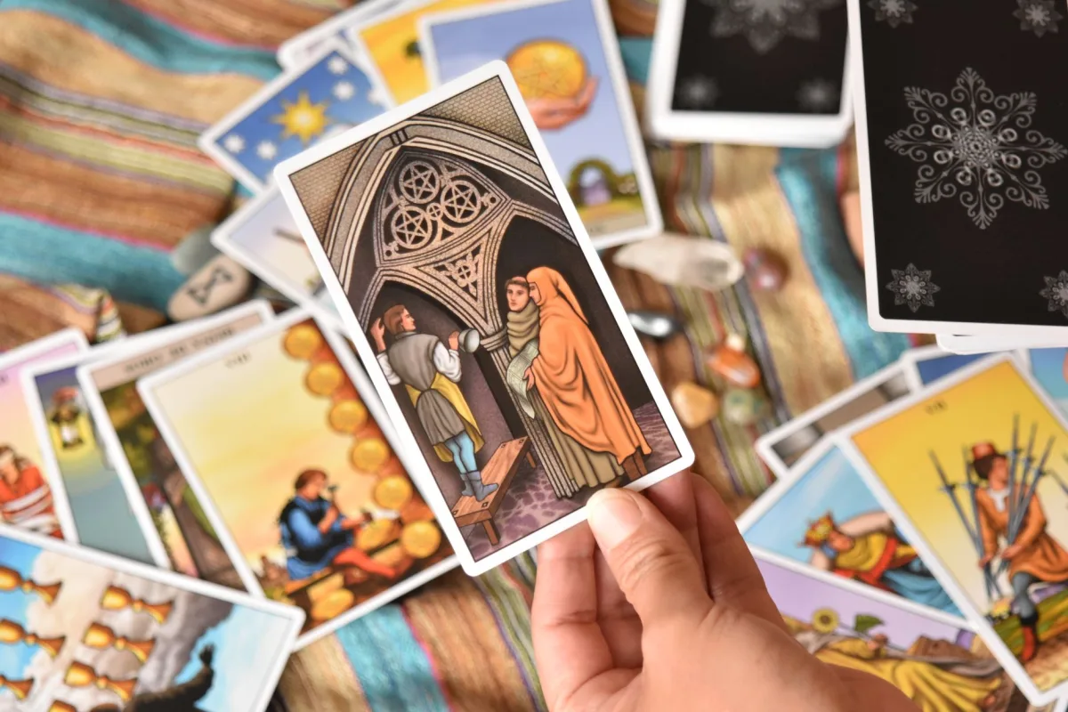 A close-up of a hand holding a tarot card during a reading session, reflecting mystical themes. A close-up of a hand holding a tarot card during a reading session, reflecting mystical themes.