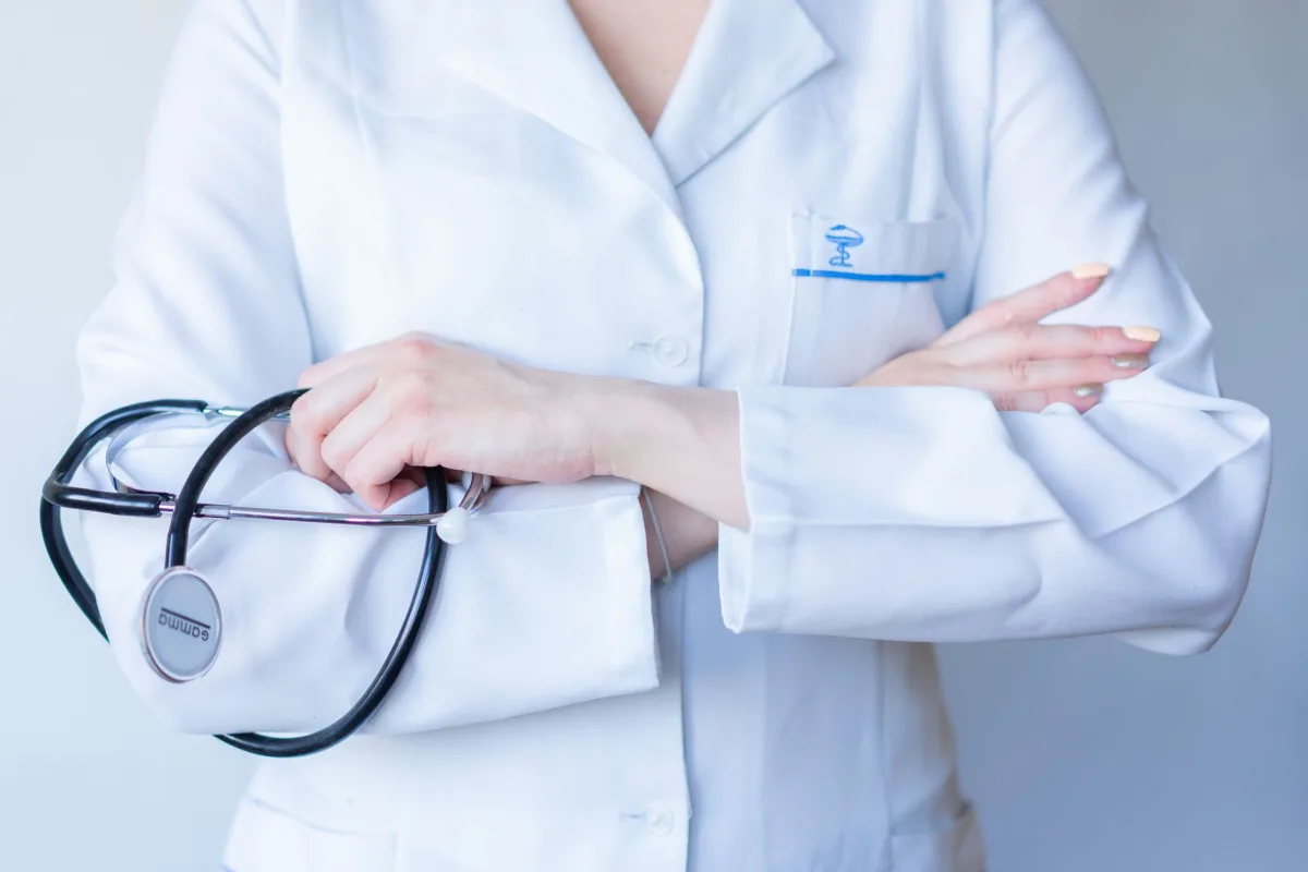 A close-up image of a doctor in a white coat with a stethoscope and arms crossed. A close-up image of a doctor in a white coat with a stethoscope and arms crossed.
