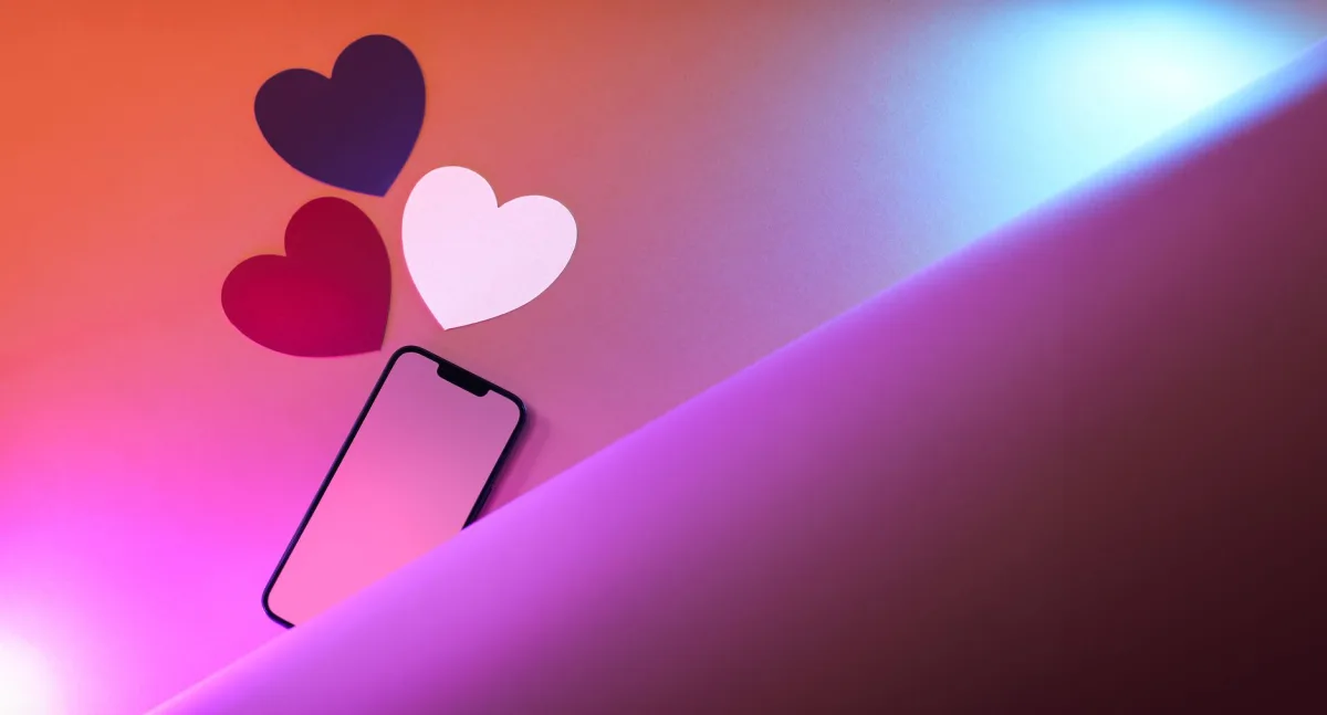 Vibrant photo of colorful hearts and a smartphone illuminated by neon lights, perfect for love-themed concepts. Vibrant photo of colorful hearts and a smartphone illuminated by neon lights, perfect for love-themed concepts.
