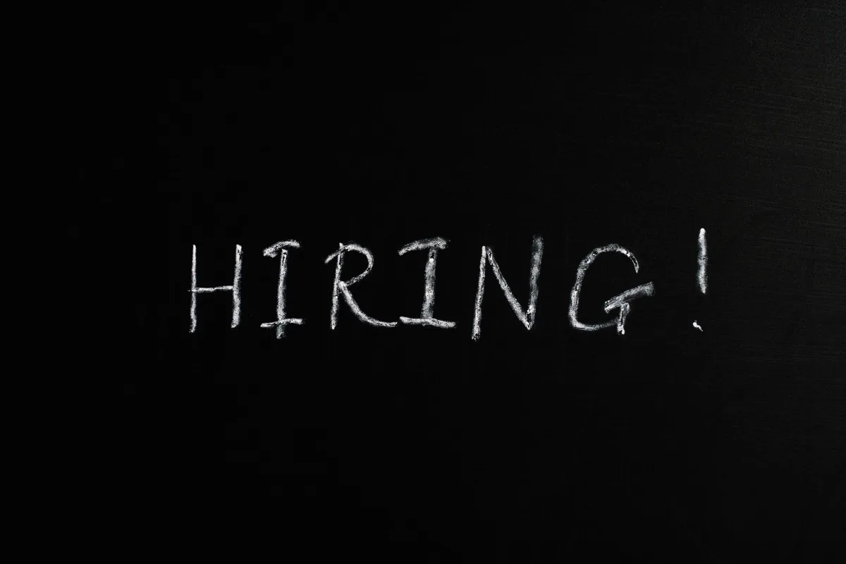 Close-up of the word 'Hiring!' written in white chalk on a blackboard, ideal for recruitment themes.