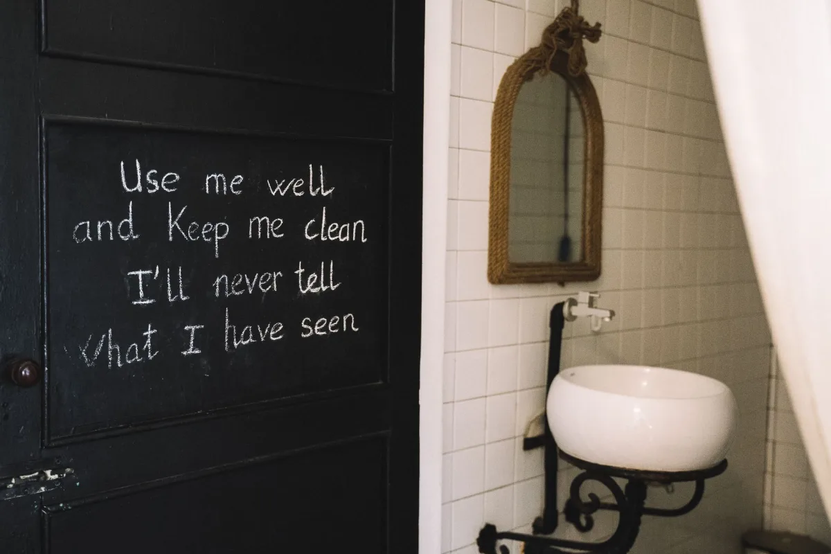 Rustic bathroom interior featuring chalkboard quote and vintage mirror. Rustic bathroom interior featuring chalkboard quote and vintage mirror.