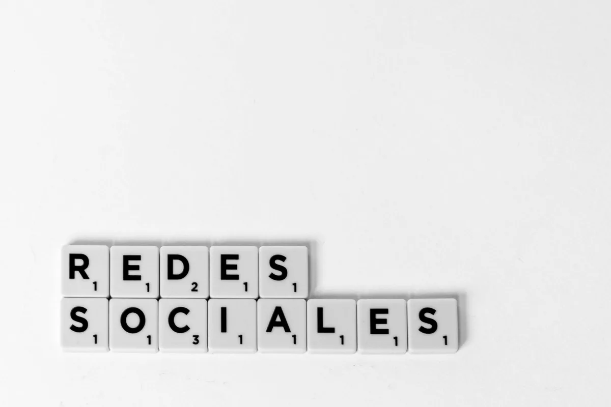 Scrabble tiles spelling 'Redes Sociales' illustrating a social media concept on a white background.