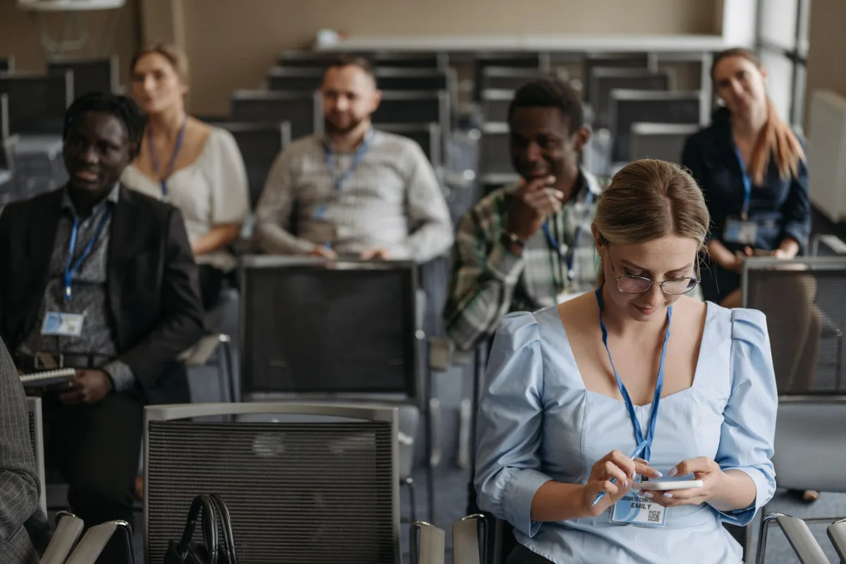 Participants sitting in a seminar room using smartphones and gadgets during a business presentation. Participants sitting in a seminar room using smartphones and gadgets during a business presentation.
