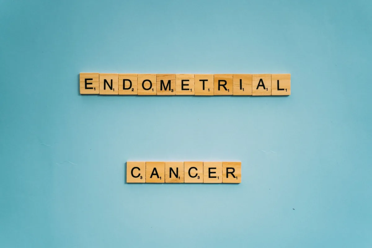 Wooden tiles spelling 'Endometrial Cancer' on a blue background promoting awareness.