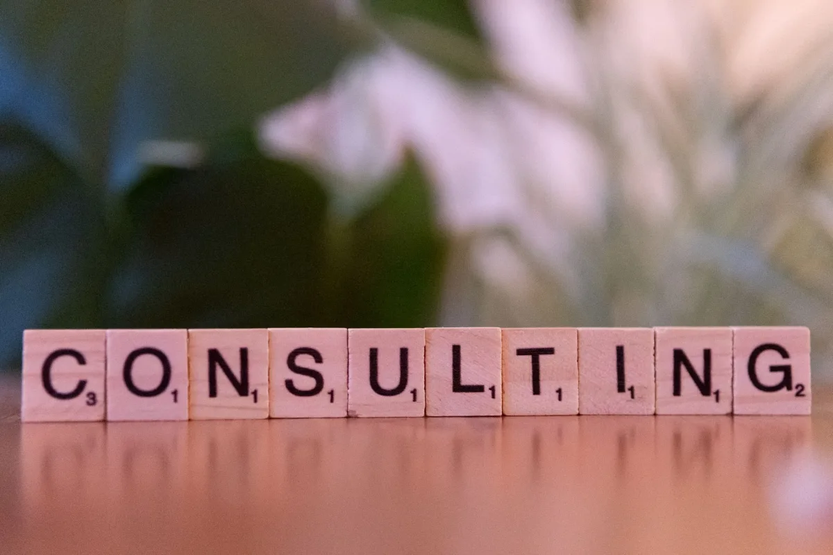 Wooden letter tiles spelling 'Consulting' with a blurred background. Ideal business concepts.