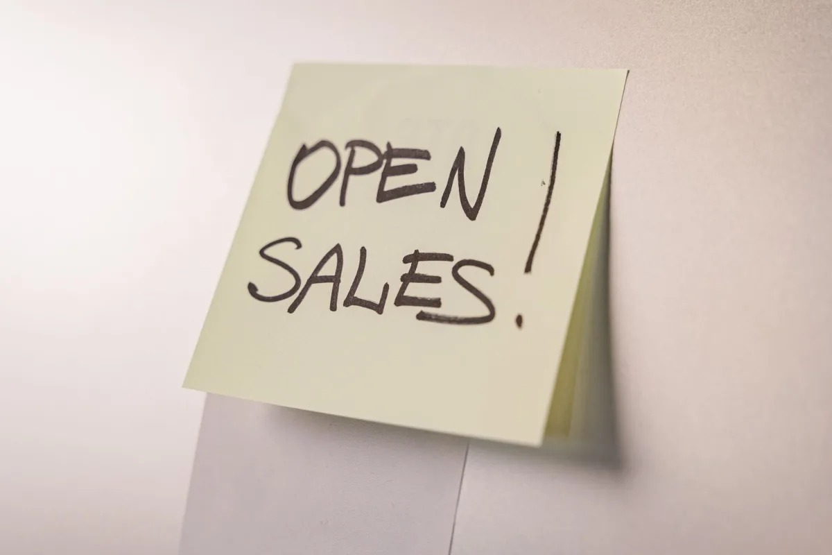 A close-up of an 'Open Sales' sticky note on a white background, ideal business promotions.