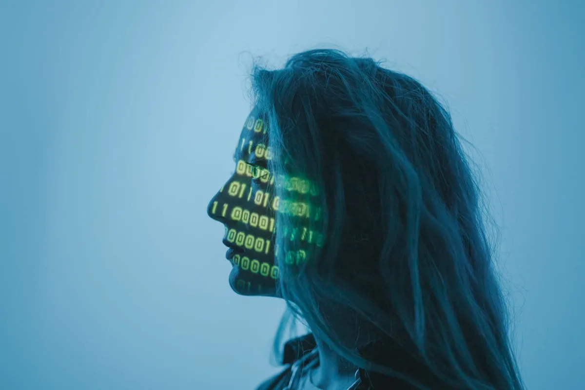 Silhouette of a woman with binary code projected on her face in a digital concept setting. Silhouette of a woman with binary code projected on her face in a digital concept setting.