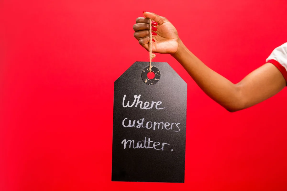 A hand holding a tag with 'Where customers matter' text on a vivid red background, emphasizing service. A hand holding a tag with 'Where customers matter' text on a vivid red background, emphasizing service.