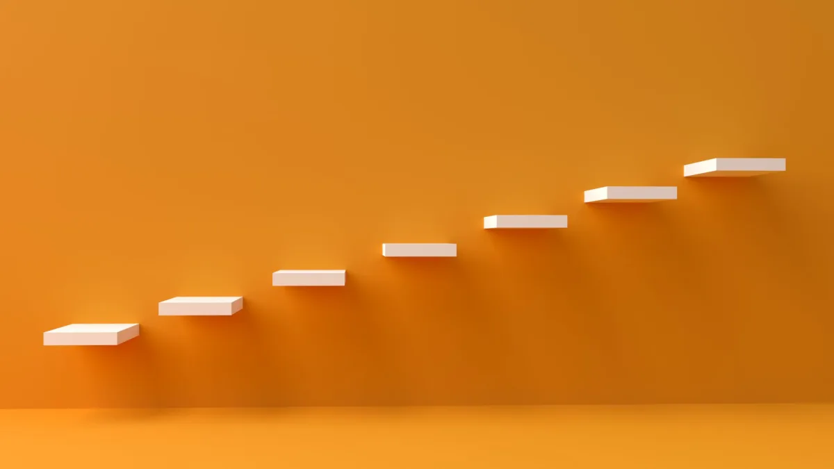White floating steps vibrant orange wall create a minimalist and conceptual design.