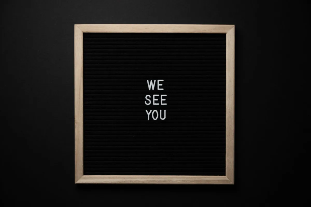 Top view black picture with white words WE SEE YOU on centre on black background