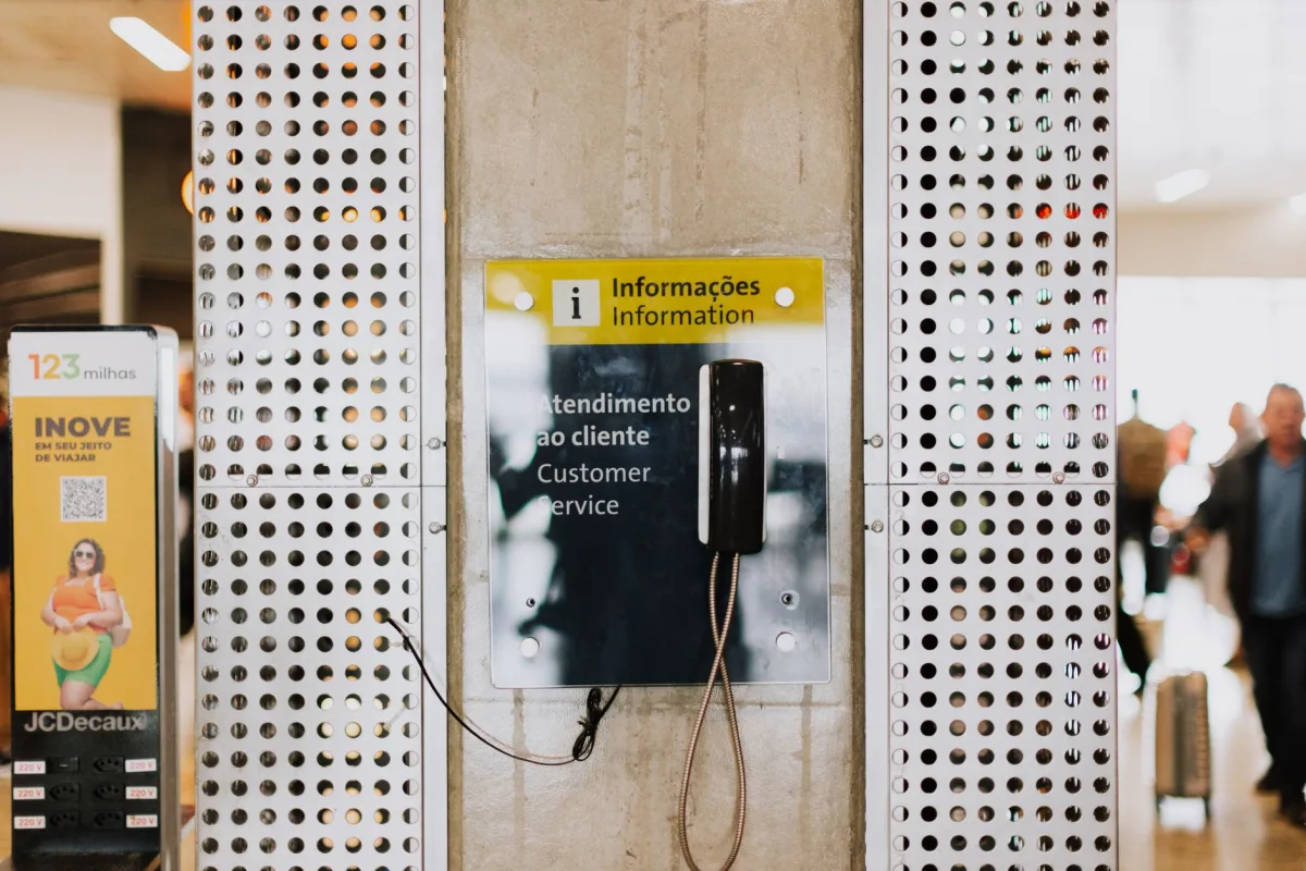 Public phone for at a bustling station entrance with signage. Public phone for at a bustling station entrance with signage.