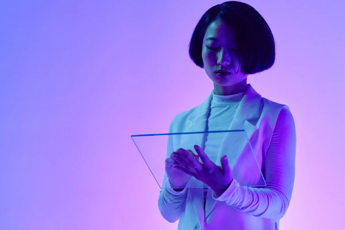 Woman interacts a transparent digital screen in vibrant studio lighting. Woman interacts a transparent digital screen in vibrant studio lighting.