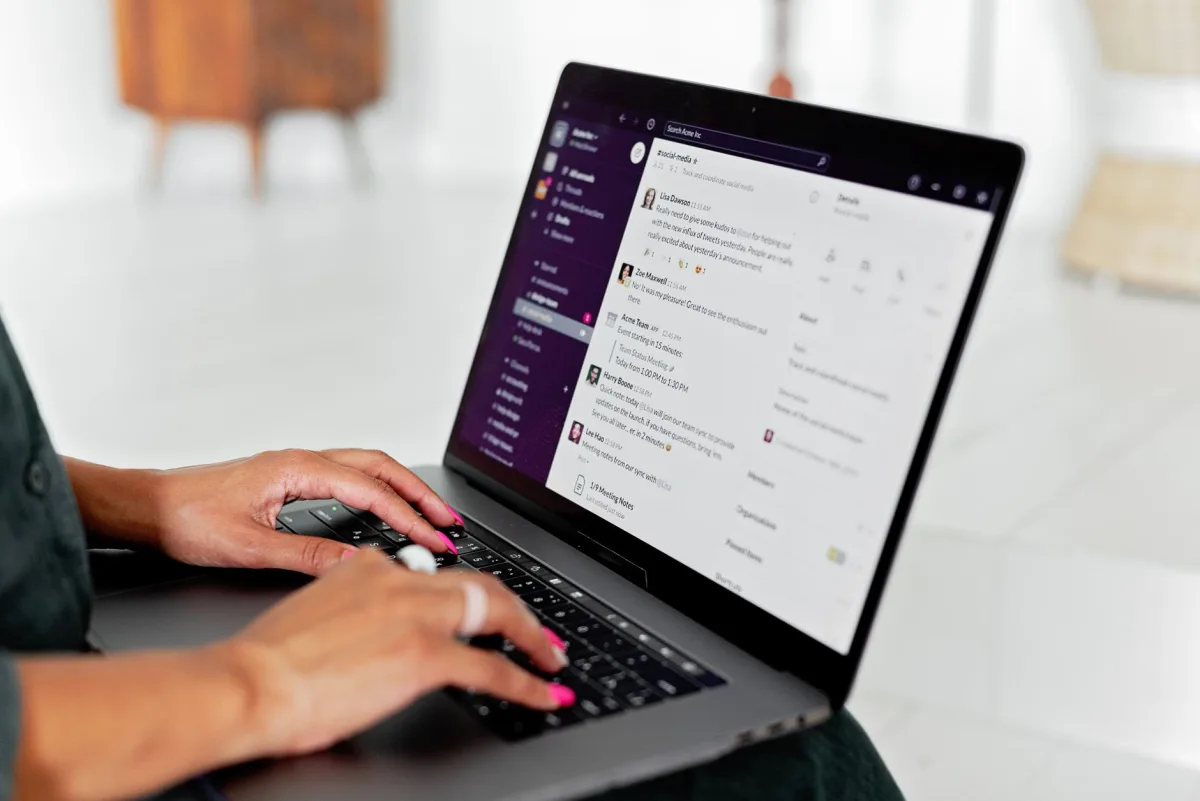 A woman types on a laptop using a app in a modern office setting. A woman types on a laptop using a app in a modern office setting.