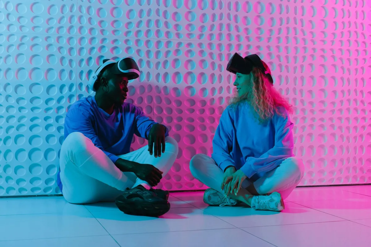Two people engage with VR headsets in a futuristic, colorful environment. Two people engage with VR headsets in a futuristic, colorful environment.