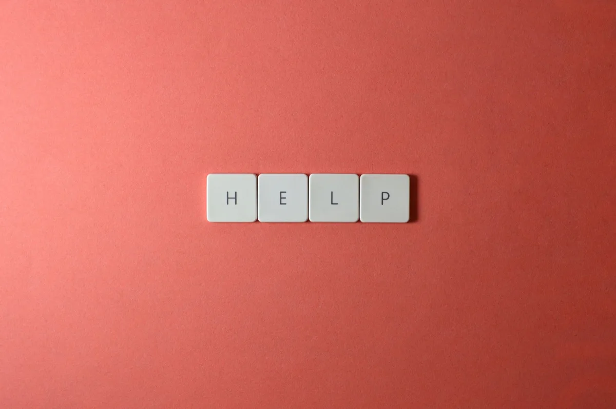 Creative layout of keyboard tiles spelling 'Help' on a red background, offering copyspace. Creative layout of keyboard tiles spelling 'Help' on a red background, offering copyspace.