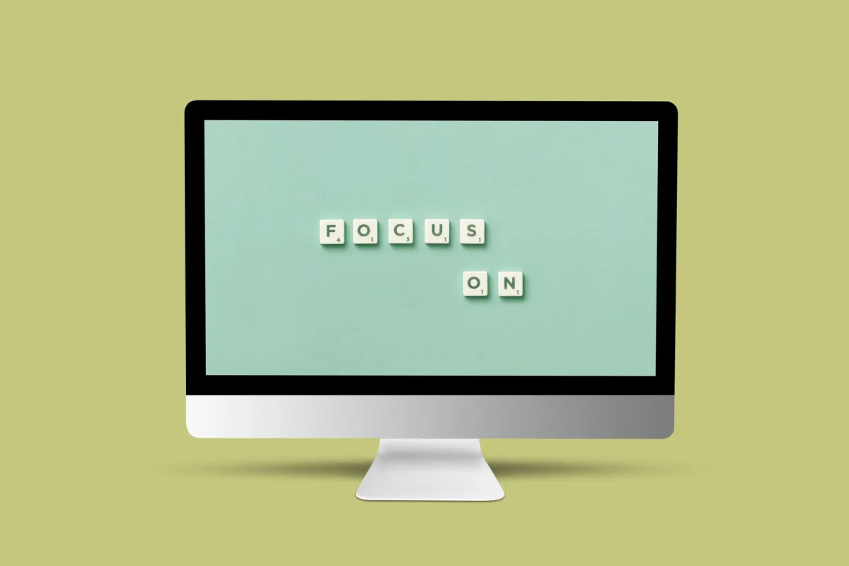 Computer monitor with 'Focus On' message using Scrabble tiles on screen for motivation and focus.