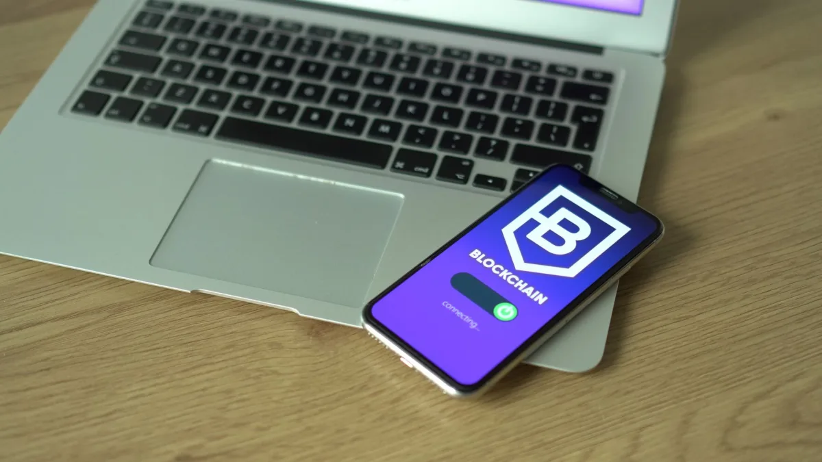 Smartphone displaying application resting on a laptop, symbolizing modern technology and finance. Smartphone displaying application resting on a laptop, symbolizing modern technology and finance.