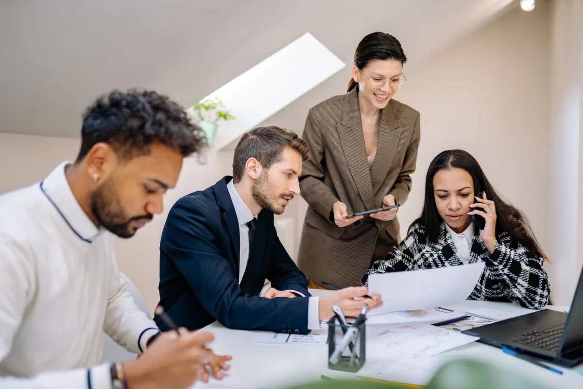 Group of professionals collaborating a bright, modern office environment with digital devices.
