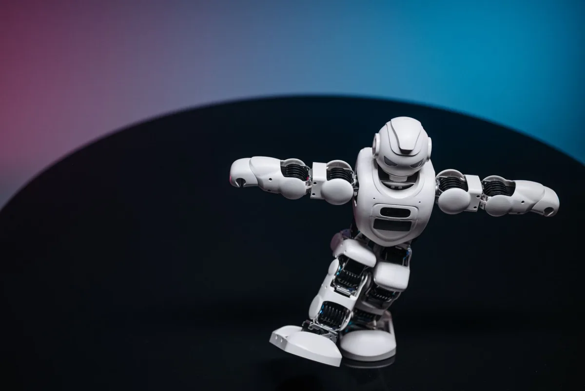 A futuristic white robot toy performing on a sleek dark surface. A futuristic white robot toy performing on a sleek dark surface.