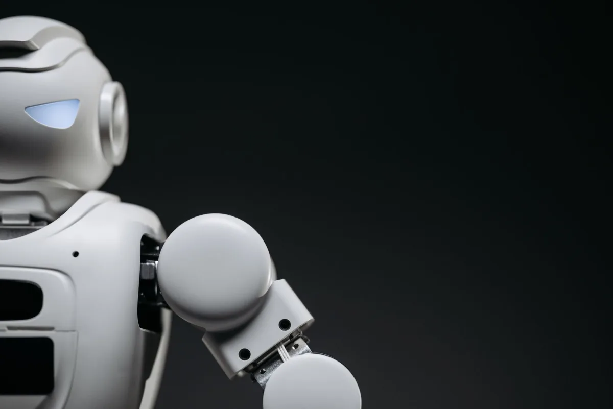 Close-up a modern, monochrome robot arm against a dark background. Futuristic technology concept. Close-up a modern, monochrome robot arm against a dark background. Futuristic technology concept.