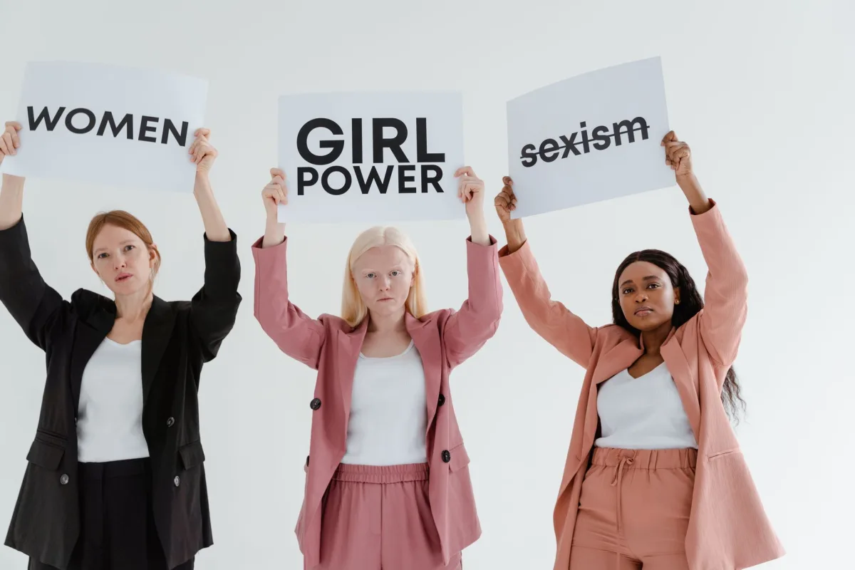 Three women holding empowering signs promoting feminism and tackling sexism. Three women holding empowering signs promoting feminism and tackling sexism.