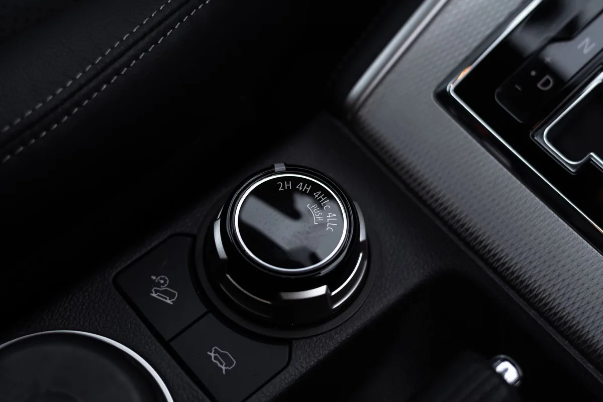 Detailed close-up of a car's gear and control knobs, showcasing modern vehicle technology.