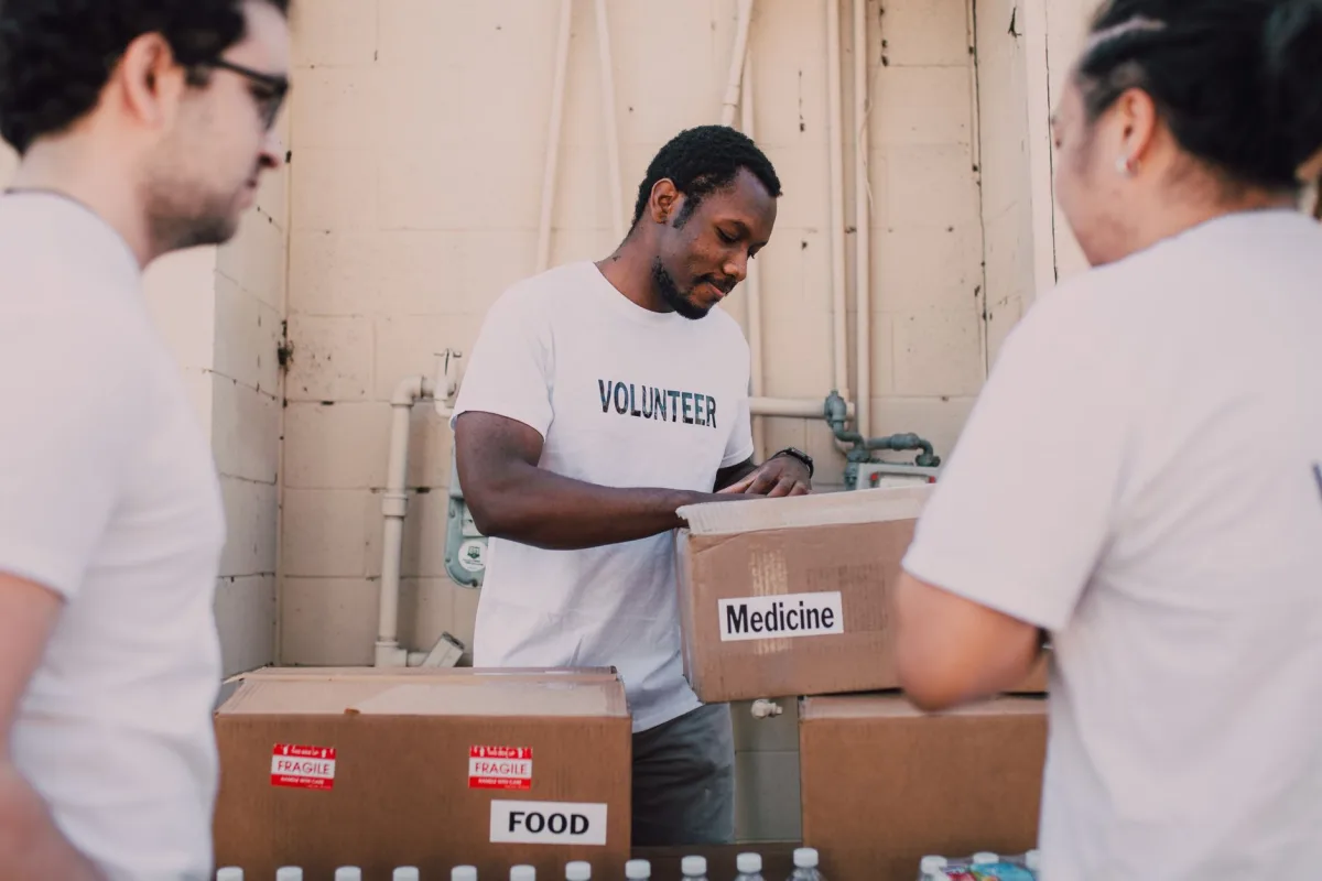 Volunteers packing food and medicine boxes for donation. Community service and support efforts. Volunteers packing food and medicine boxes for donation. Community service and support efforts.