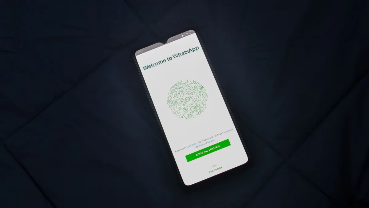Smartphone displaying WhatsApp login screen on a dark surface. Overhead view. Smartphone displaying WhatsApp login screen on a dark surface. Overhead view.