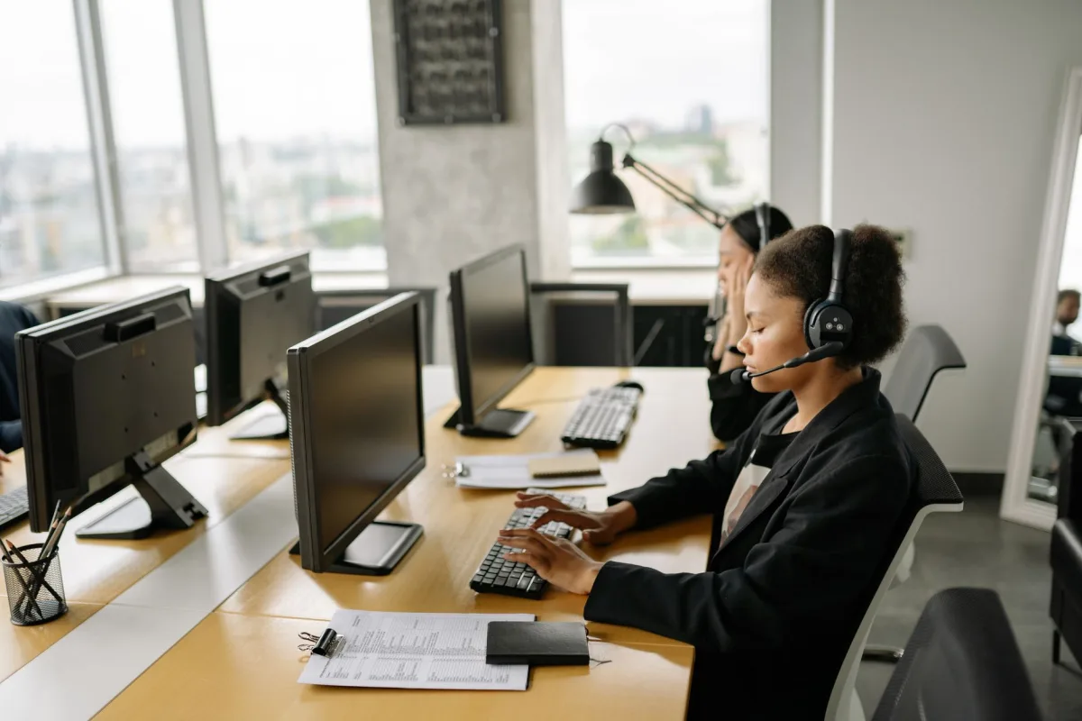 support agents working at a call center with computers and headsets, focusing on tasks. support agents working at a call center with computers and headsets, focusing on tasks.