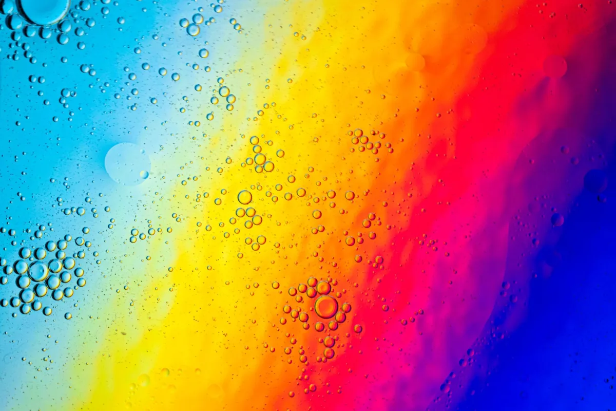 Colorful oil bubbles on a gradient spectrum background creating abstract patterns.