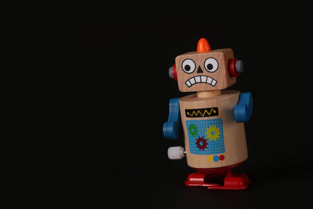 A vibrant wooden toy robot stands on a dark surface, showcasing vivid colors and playful design. A vibrant wooden toy robot stands on a dark surface, showcasing vivid colors and playful design.