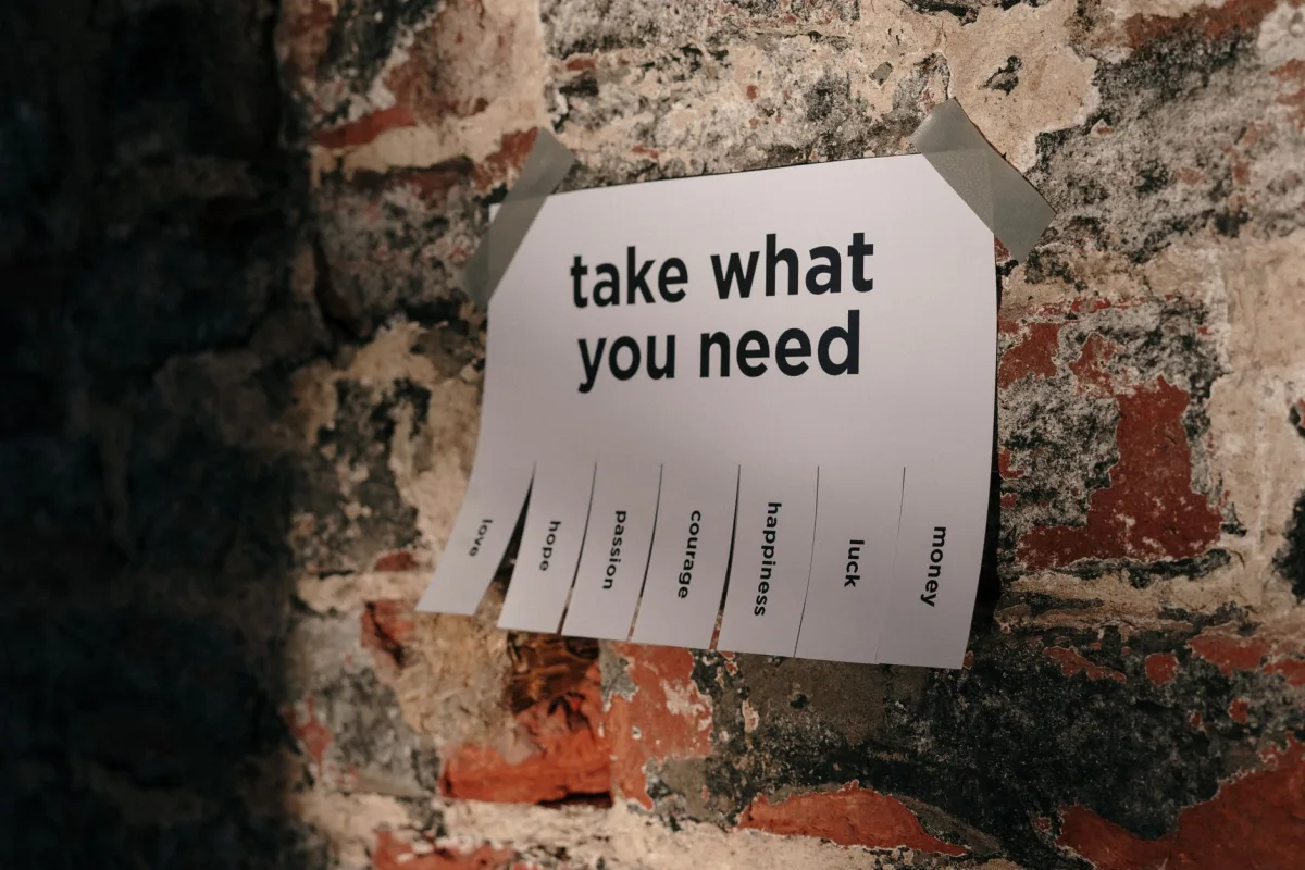A motivational note offering positive qualities taped to a brick wall. A motivational note offering positive qualities taped to a brick wall.