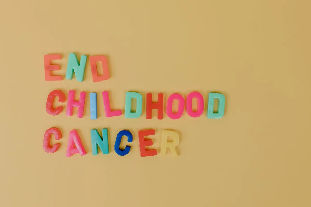 Colorful letters spelling 'End Childhood Cancer' on a yellow background promoting cancer awareness. Colorful letters spelling 'End Childhood Cancer' on a yellow background promoting cancer awareness.
