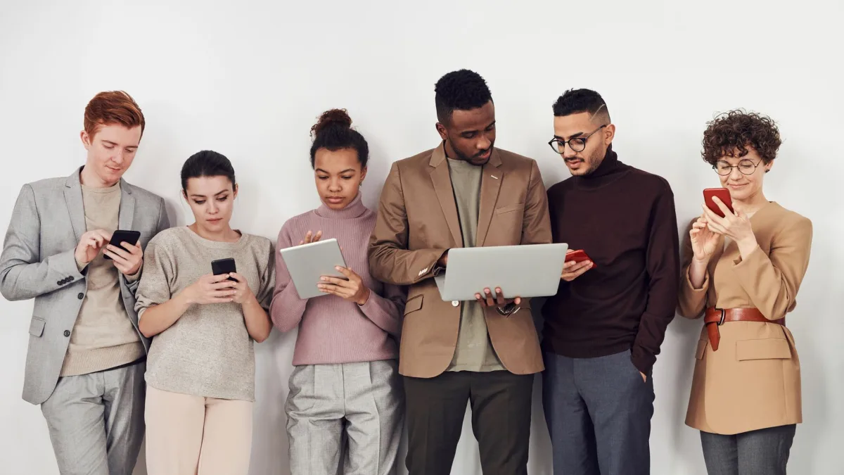 A diverse group of young adults using mobile devices. Perfect for business and technology themes.