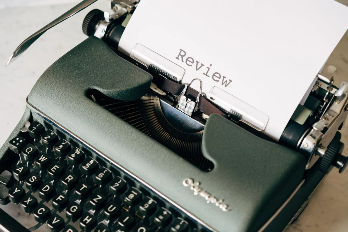 Classic green typewriter with paper displaying 'Review', perfect for creative themes.